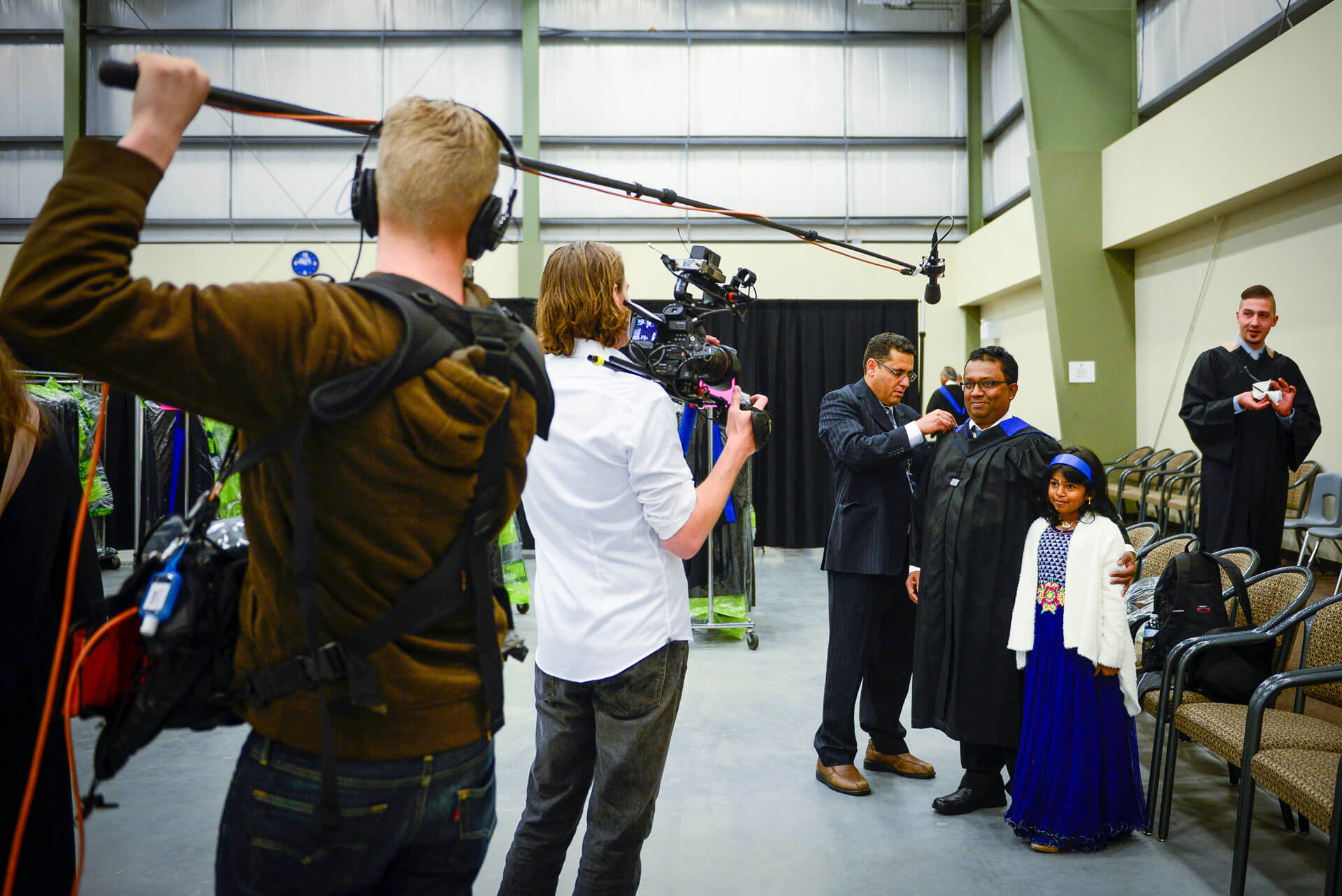 video crew films a graduate and their family inside the Athabasca Regional Multiplex