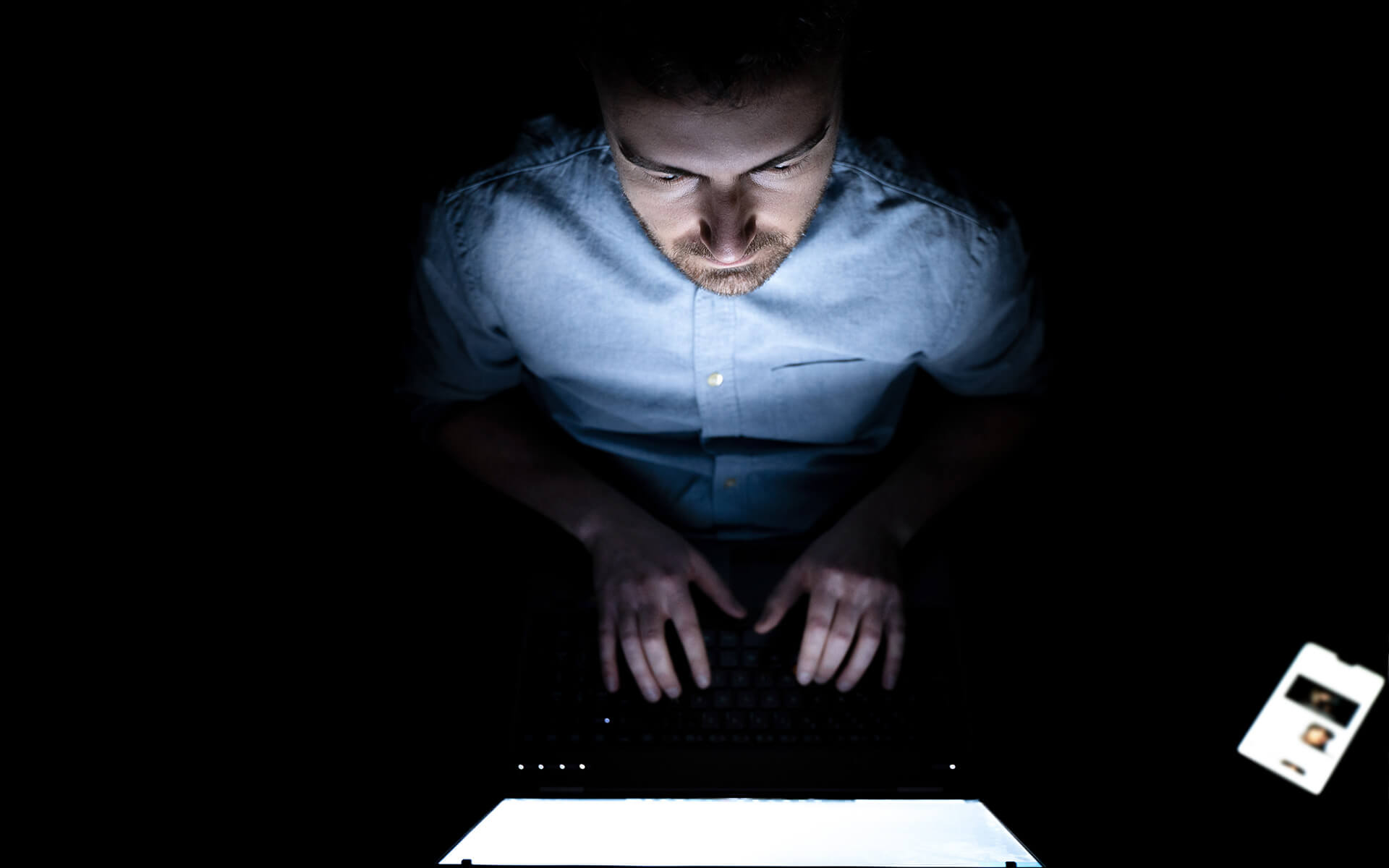 man using computer in dark room - digital addiction at work