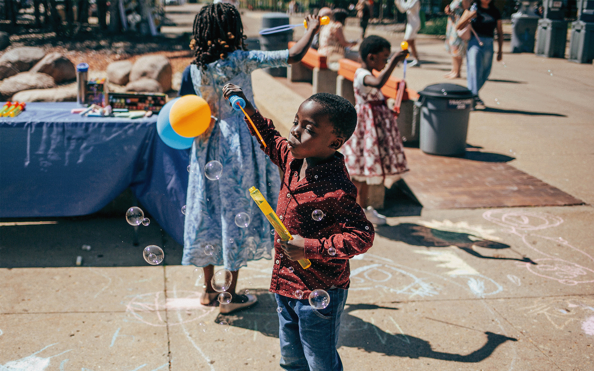 Young child playing with bubbles at the convocation festival after the ceremonies