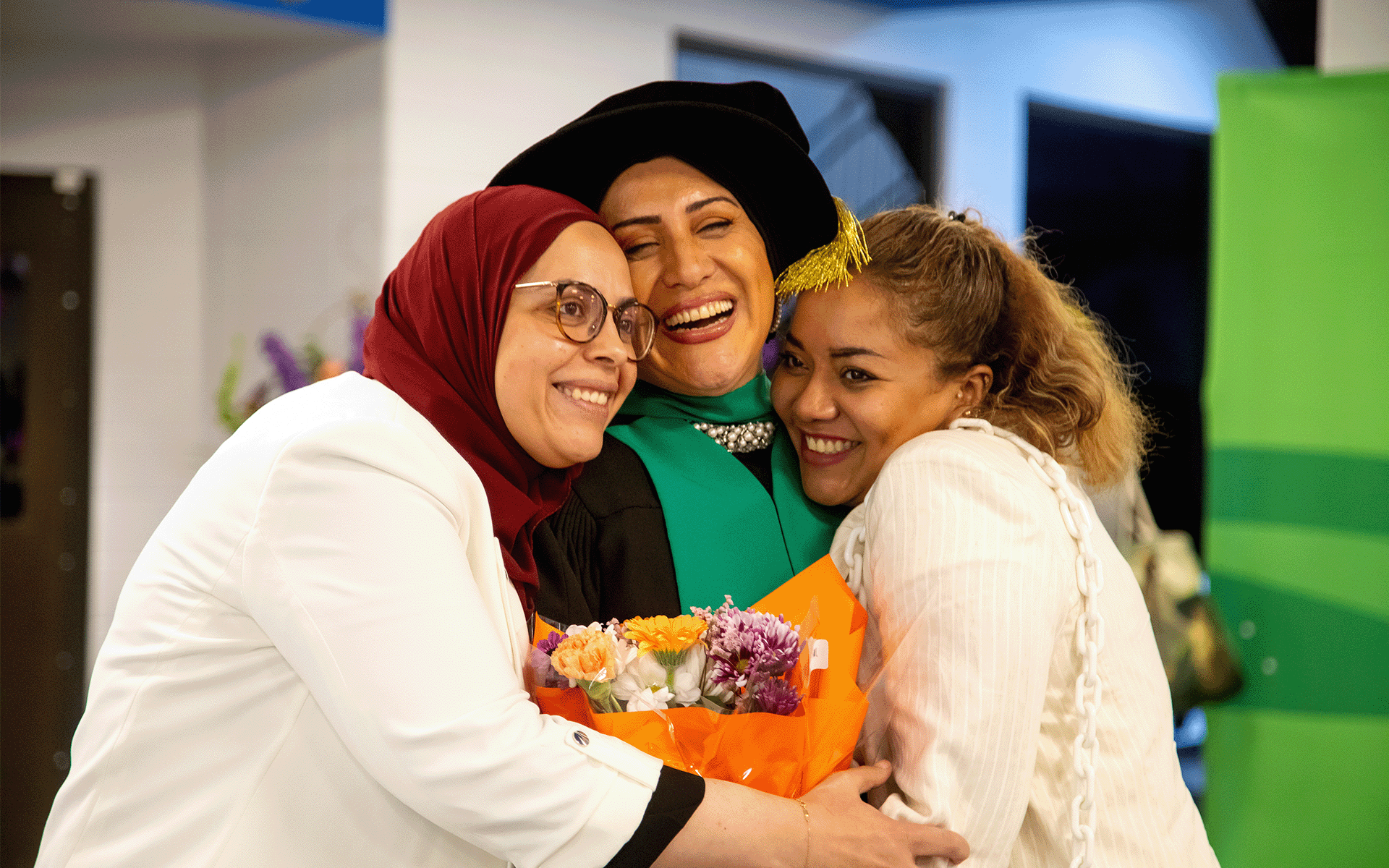 A trio of woman hugging and smiling.
