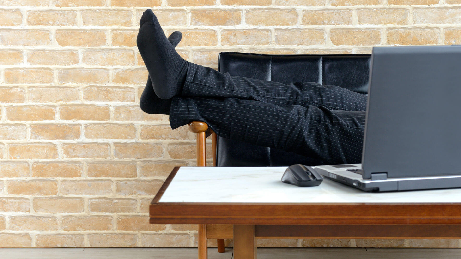 person with feet up in front of laptop