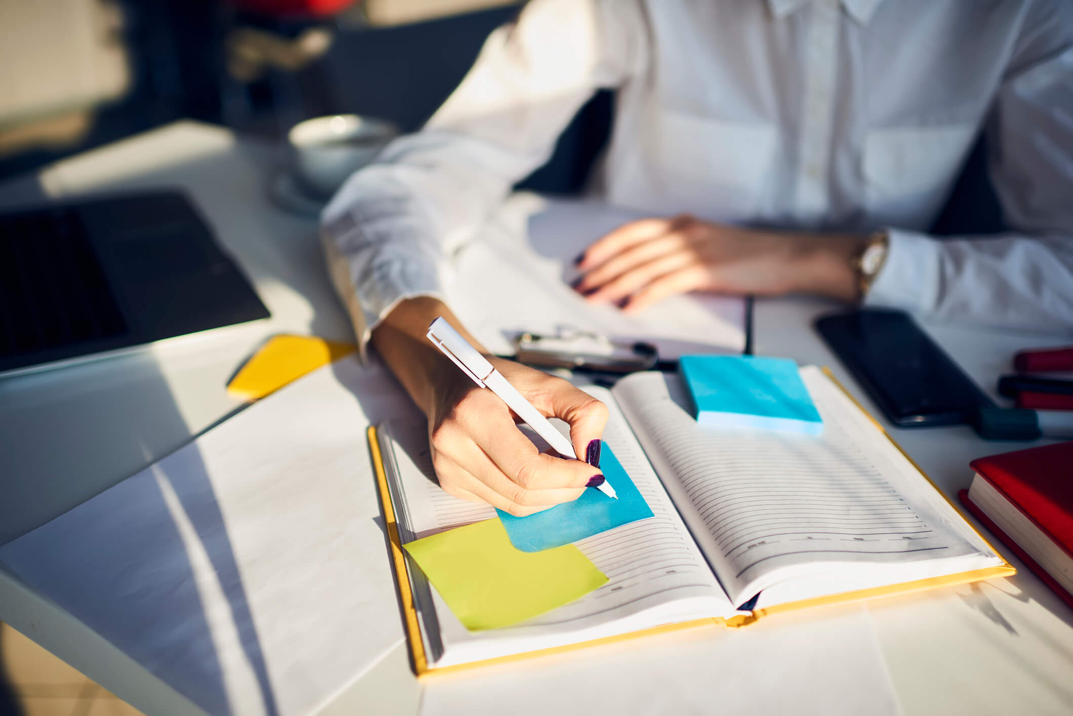 using an agenda with yellow and blue sticky notes to organize