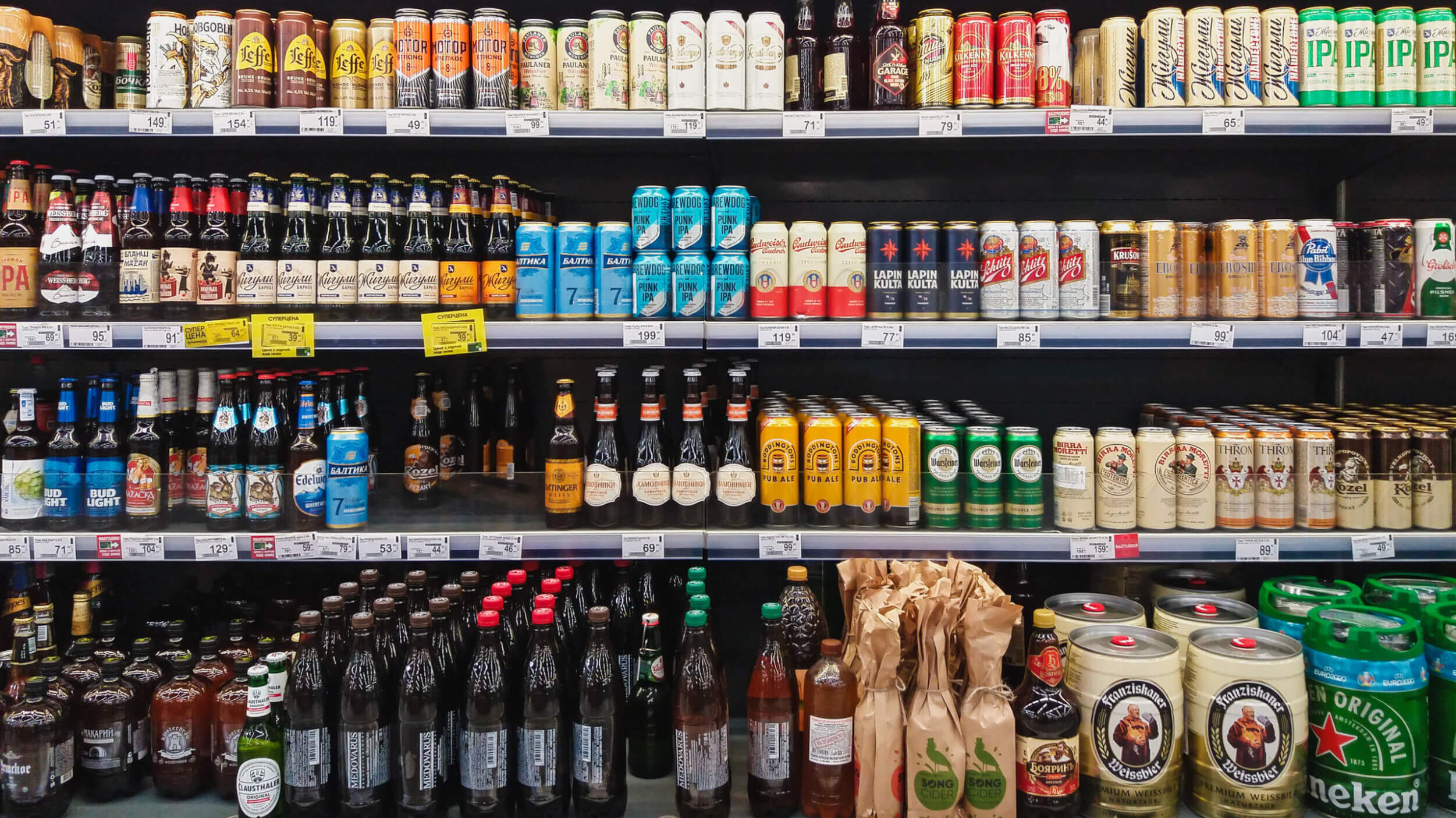 Beer in bottles and cans on grocery store shelves