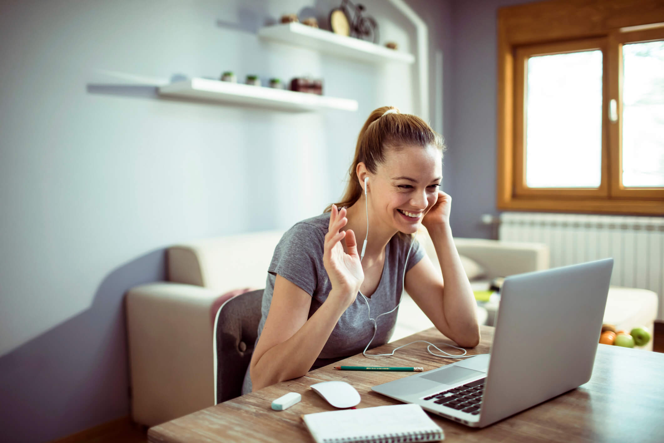 Close up of a young woman using a laptop for teleconferencing at home