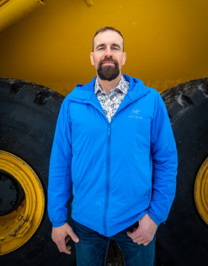 Bob Willows standing in front of heavy equipment