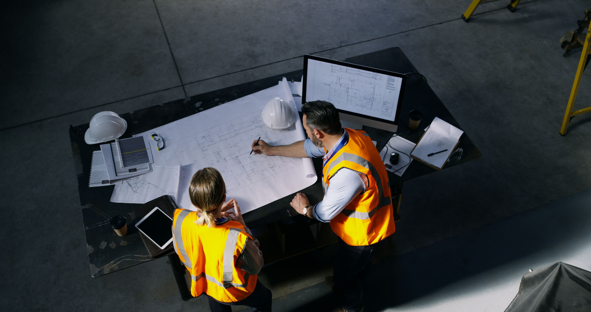 High angle shot of two architects going over a blueprint together in an industrial place of work