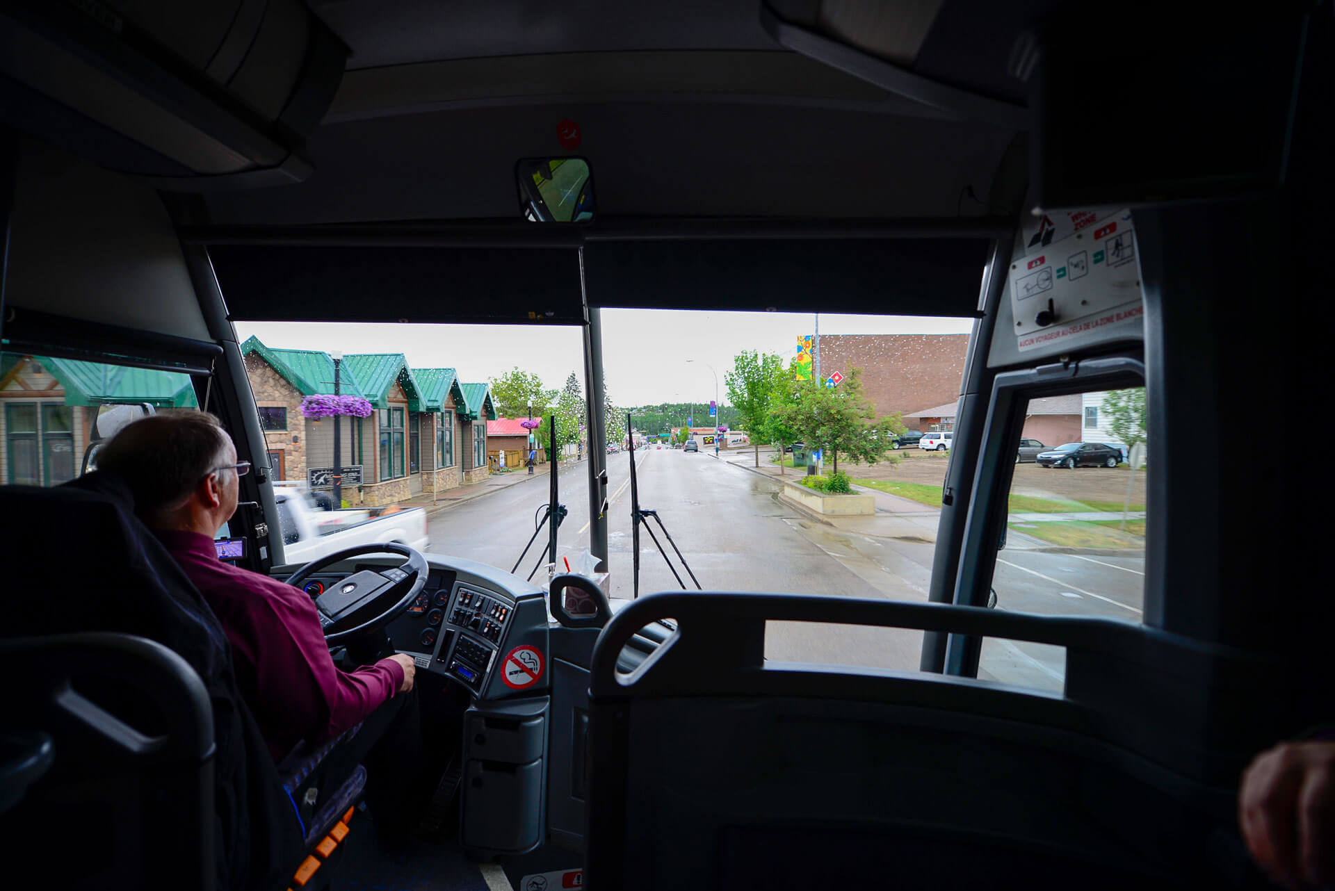 view of a street in Athabasca from inside a charter bus