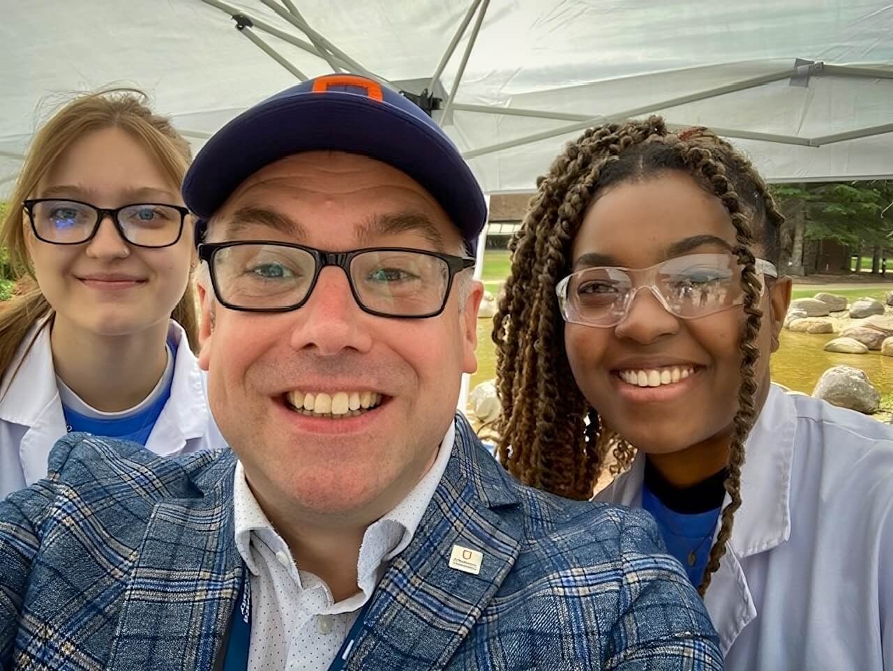 AU president Dr. Alex Clark takes a selfie with two staffers at homecoming in Athabasca.