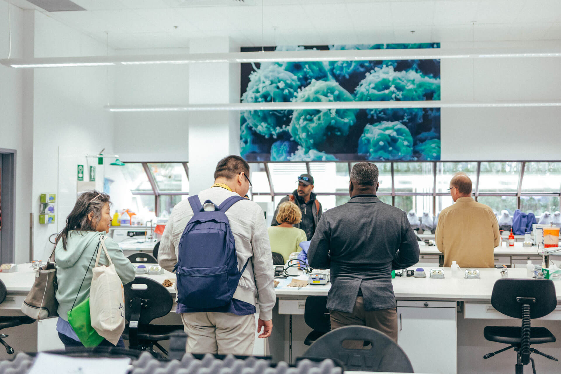 a group of people tour the science lab at Athabasca University’s main campus for homecoming June 18.