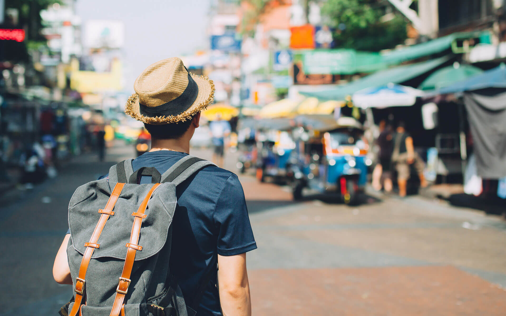 Young traveller backpacking in Khaosan Road outdoor market in Bangkok, Thailand