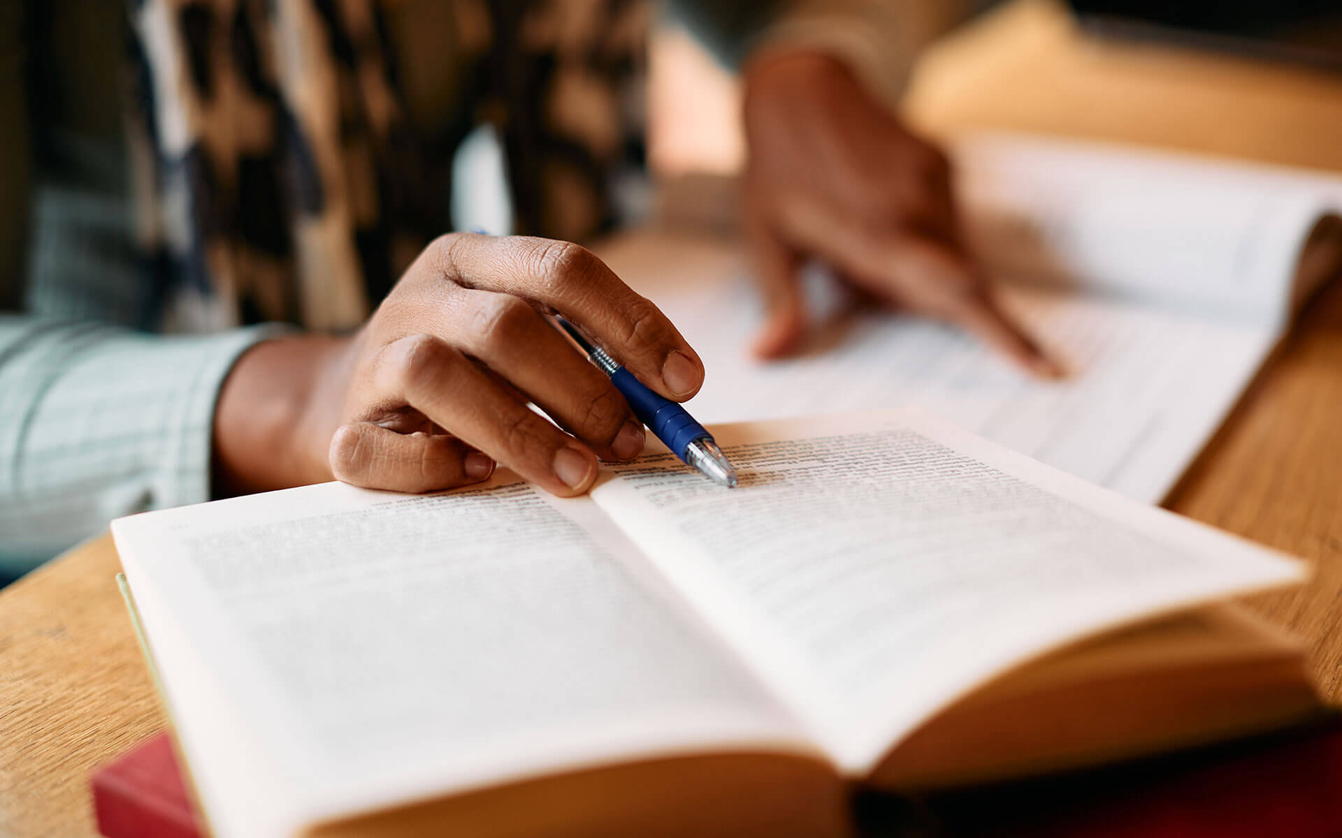 close-up of a person's hands reading a book