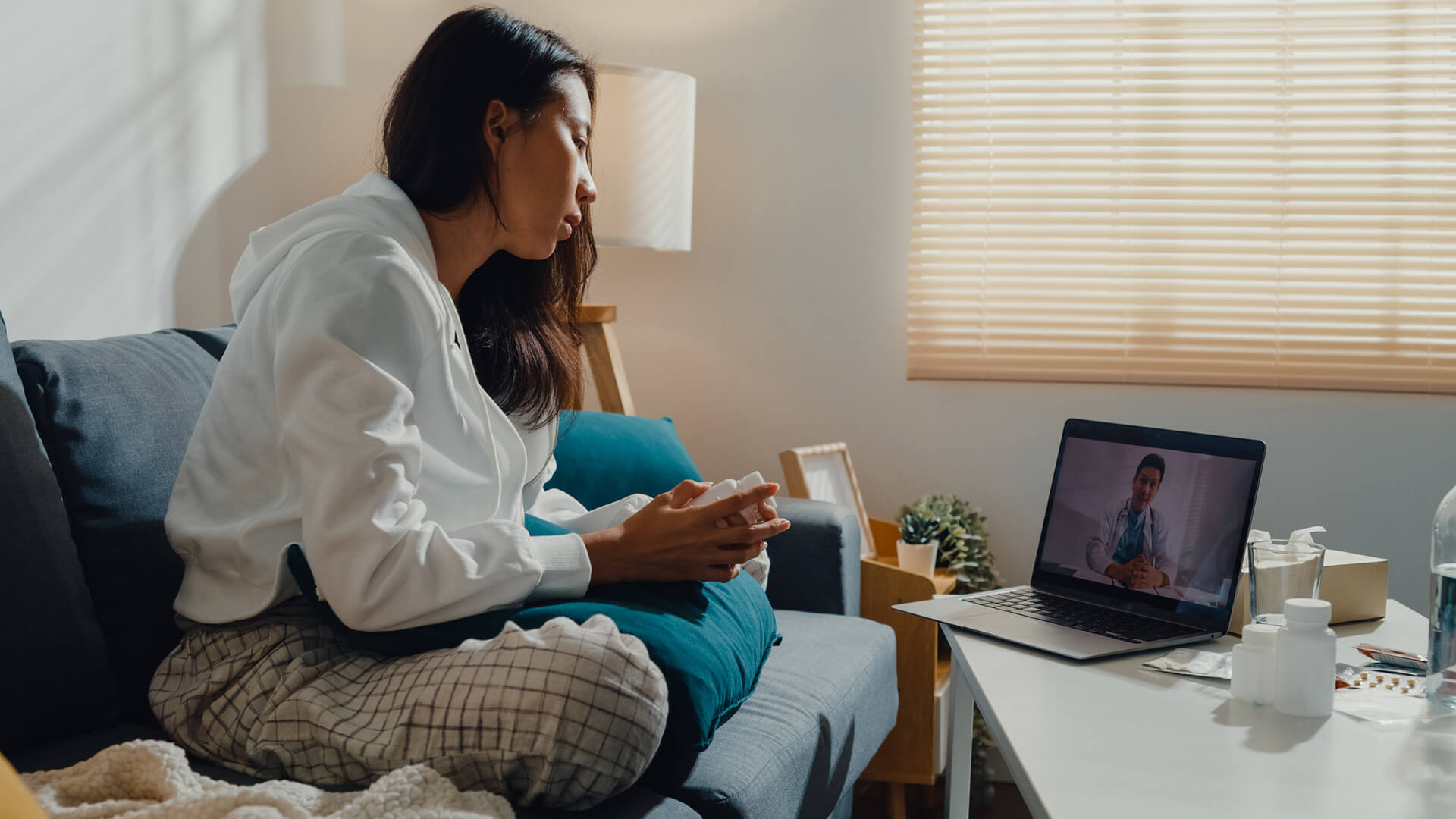 woman sitting on couch looking at call on a computer