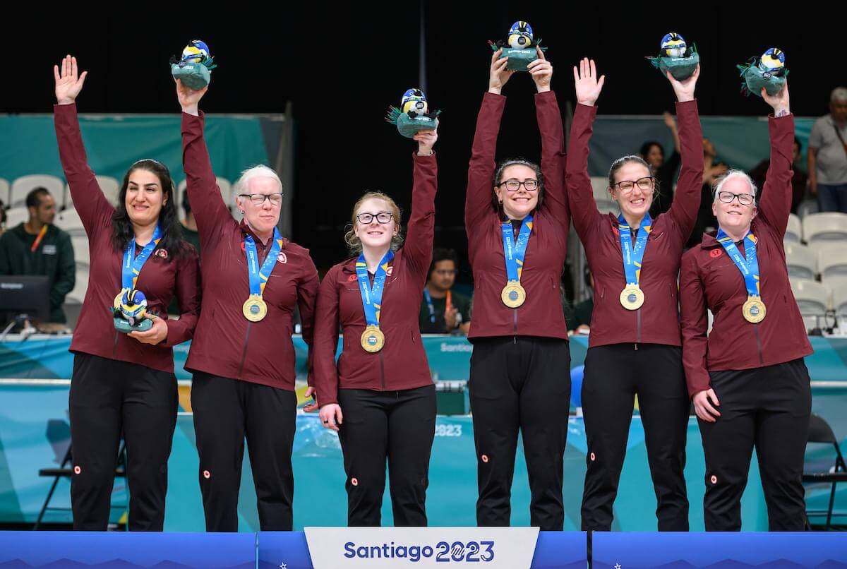 Baldock and her Team Canada teammates celebrating their Santiago gold medal win at the podium