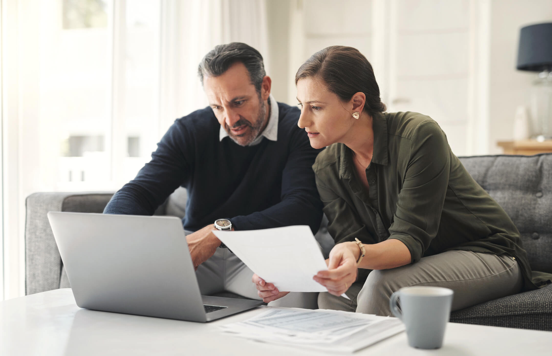 Couple working together, contemplating their investments