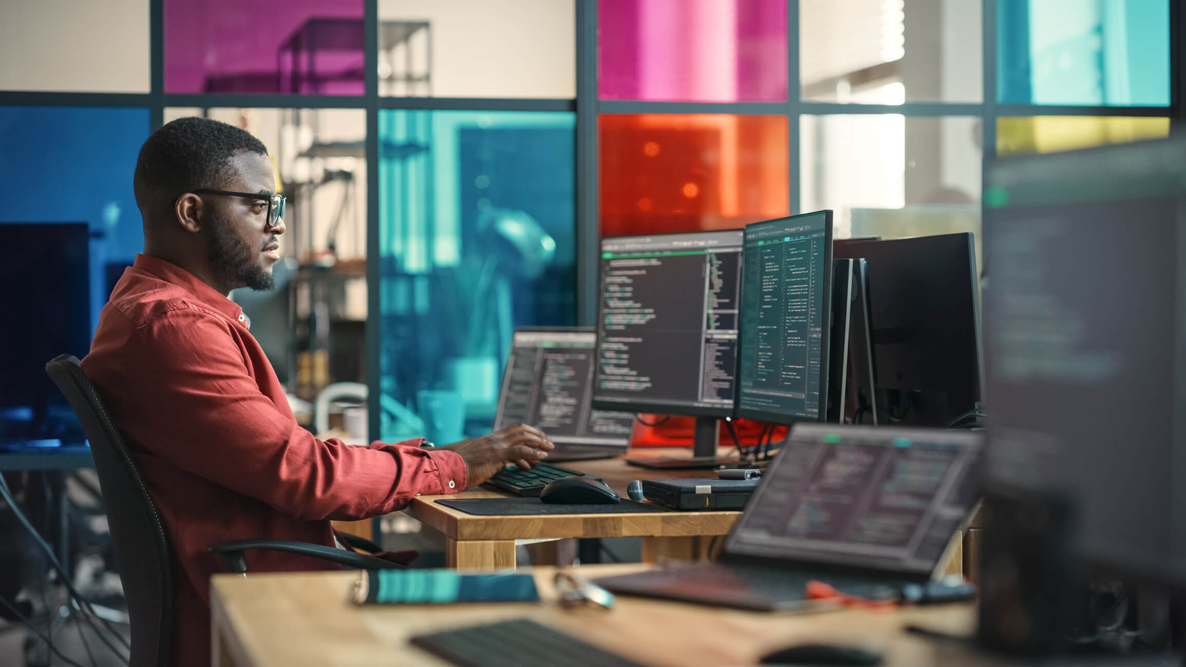 A man writing code on a desktop computer