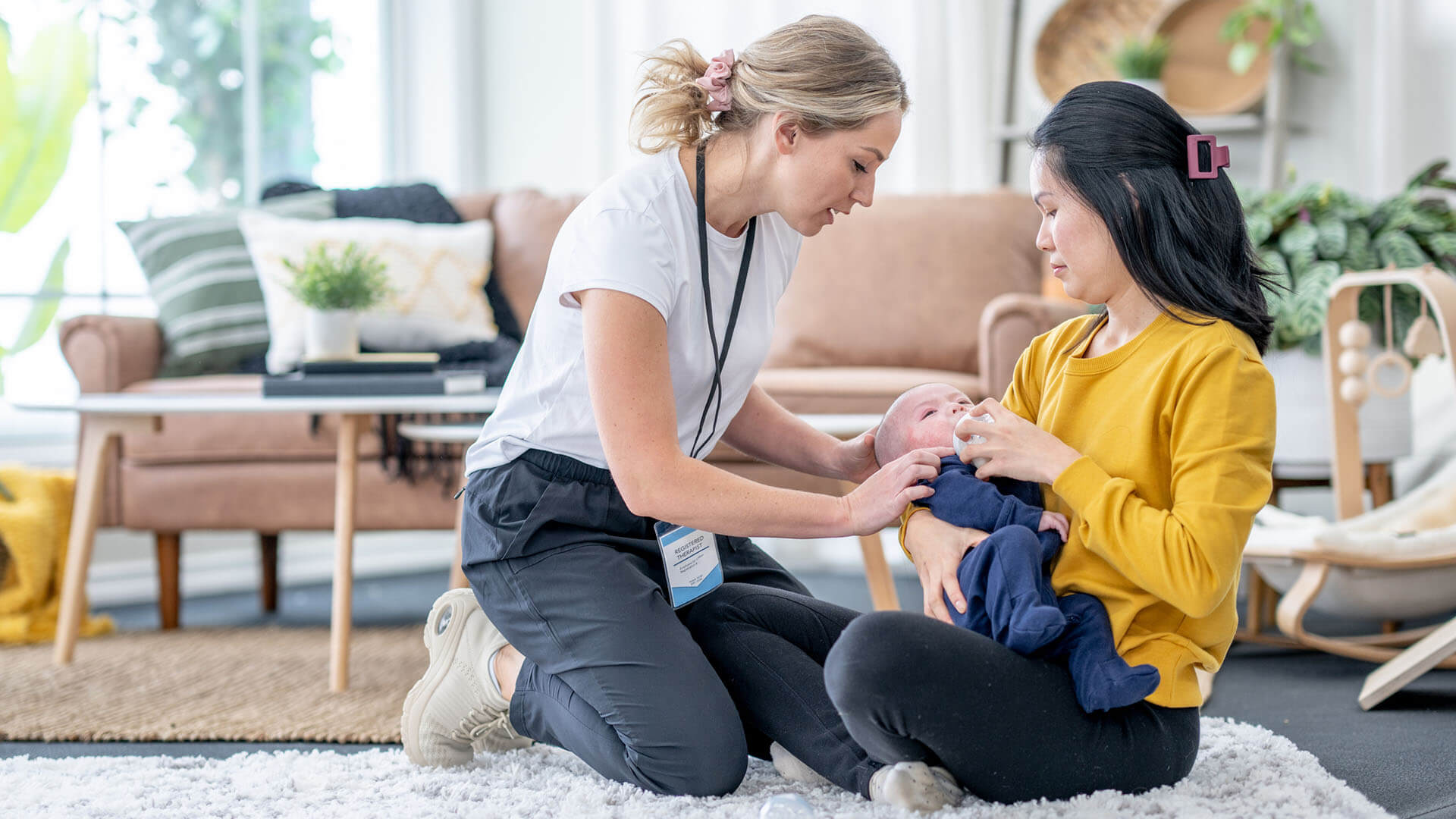 Lactation consultant teaching a mother about baby feeding techniques