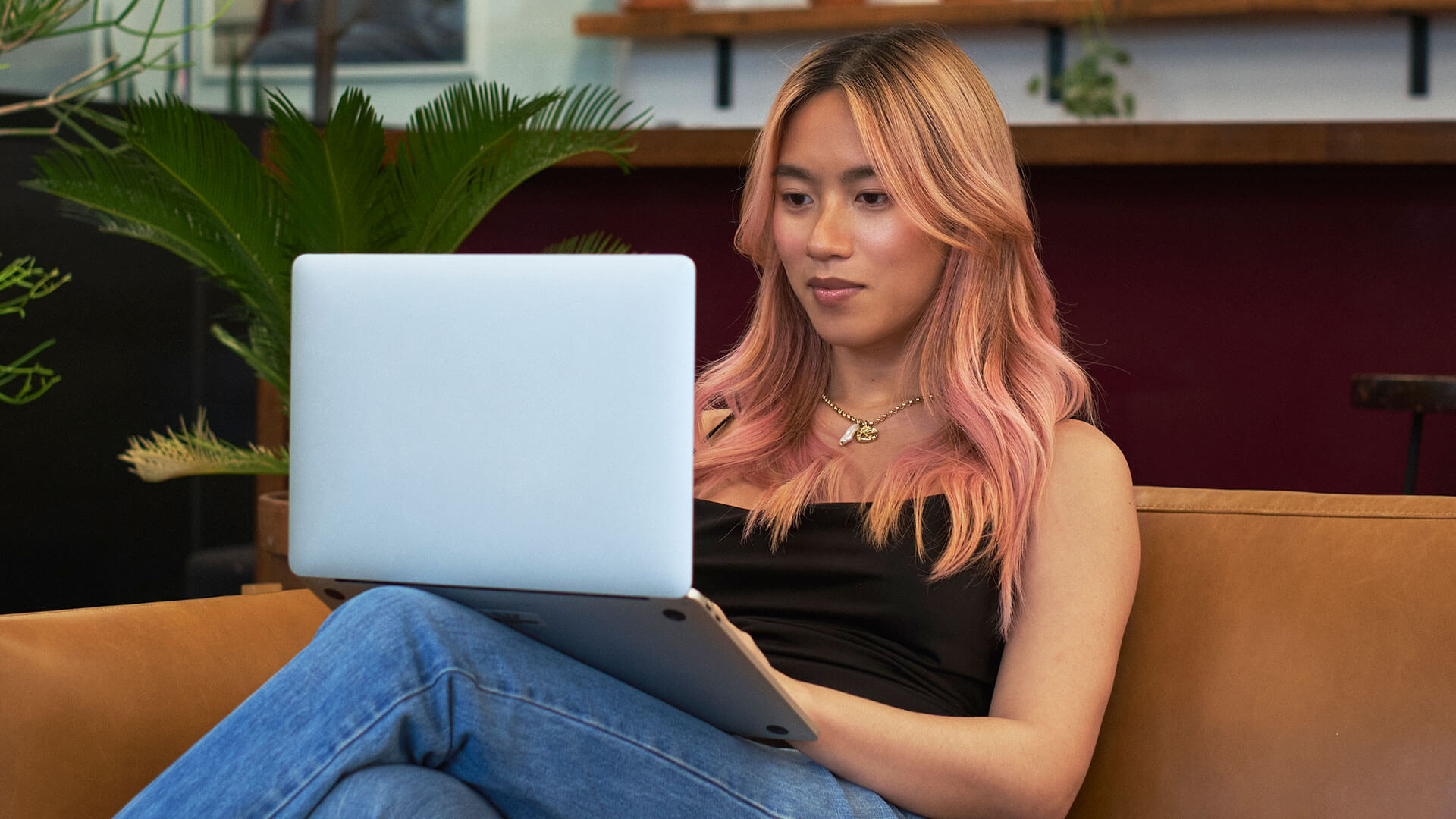 A transfeminine person using a laptop at work