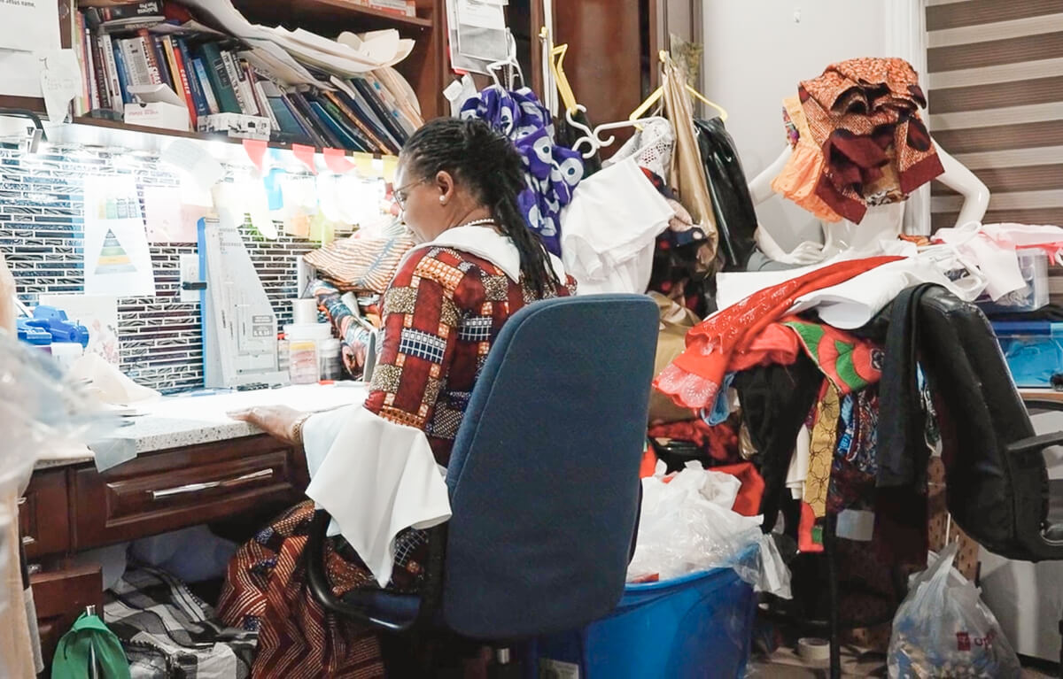 Lilian Amaka Okocha sitting at her desk in her sewing room